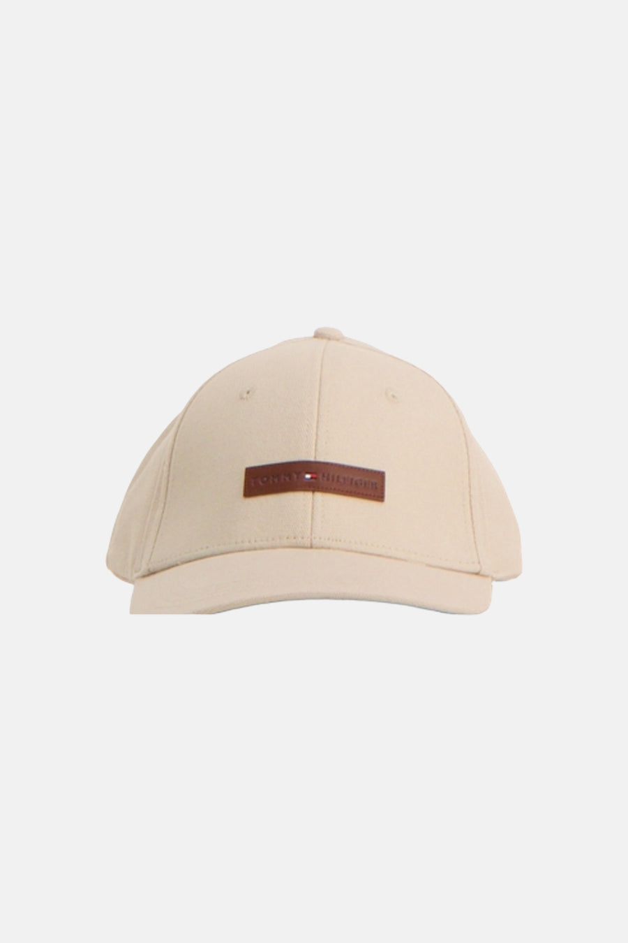 Casquette beige de TOMMY JEANS, avec une étiquette marron ornée du logo.
