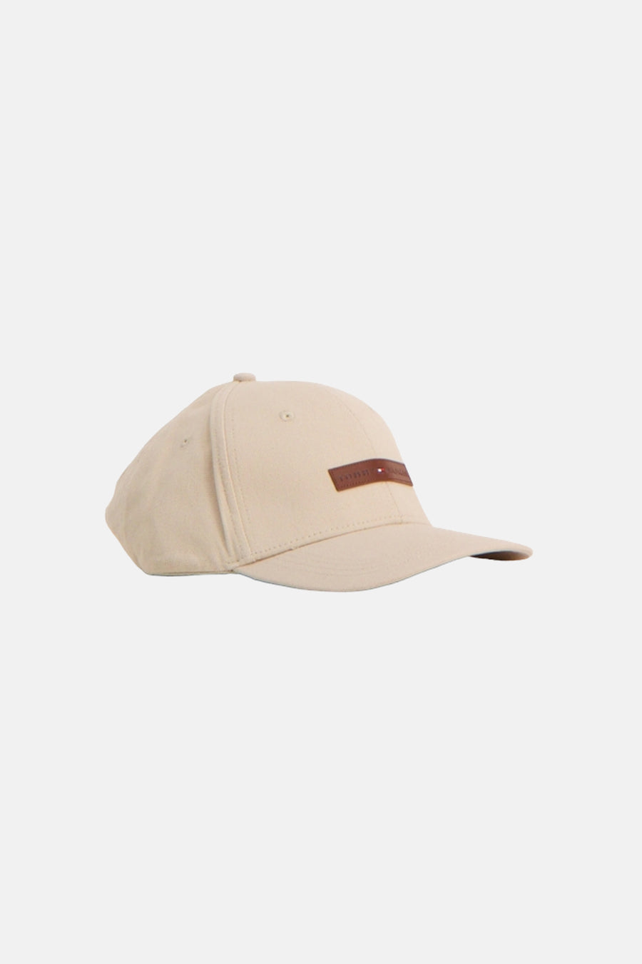 Casquette beige de TOMMY JEANS, avec une étiquette en cuir marron sur le devant.