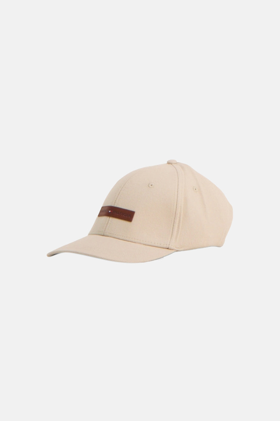 Casquette beige de TOMMY JEANS, avec une étiquette en cuir marron portant le logo de la marque.