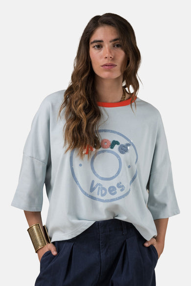 Blauw T-shirt met korte mouwen van ADORE, met decoratieve print en oranje kraag, gedragen met een blauwe broek.