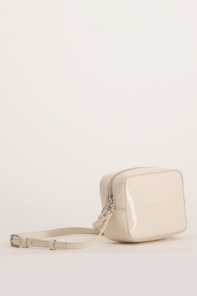 Sac à bandoulière écru de Tommy Jeans, avec une bandoulière réglable et fermeture zippée argentée.
