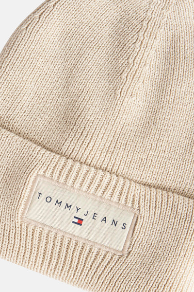 Beige gebreide muts van TOMMY JEANS, met een opgenaaid logolabel op de onderrand.