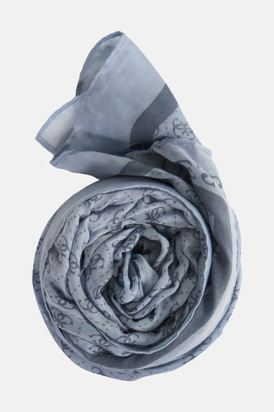 Blauwe foulard van Guess, spiraalsgewijs gedrapeerd, met toon-op-toon patronen en decoratieve strepen.