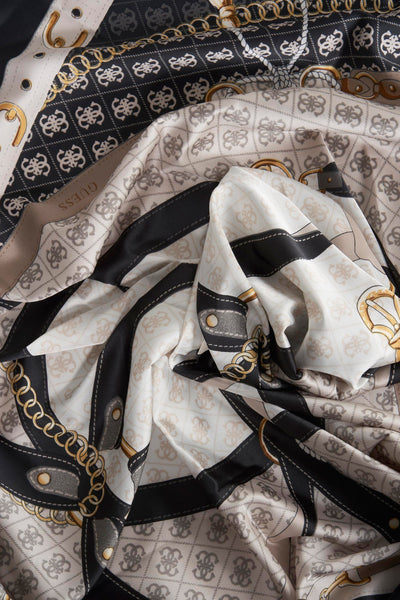 Foulard multicolore de Guess, avec motifs de chaînes, boucles et monogrammes entrelacés sur soie froissée.
