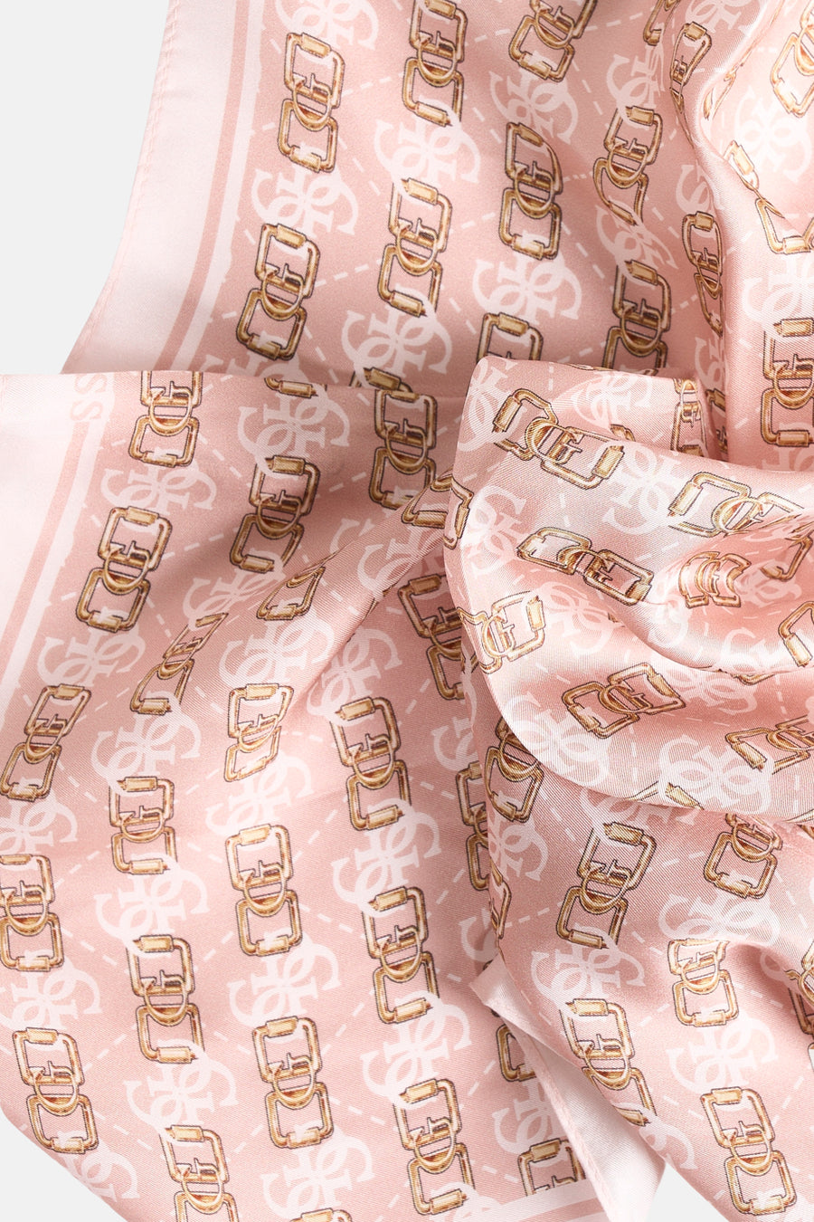 Foulard rose signé Guess, avec un motif de boucles dorées et le logo de la marque en blanc.