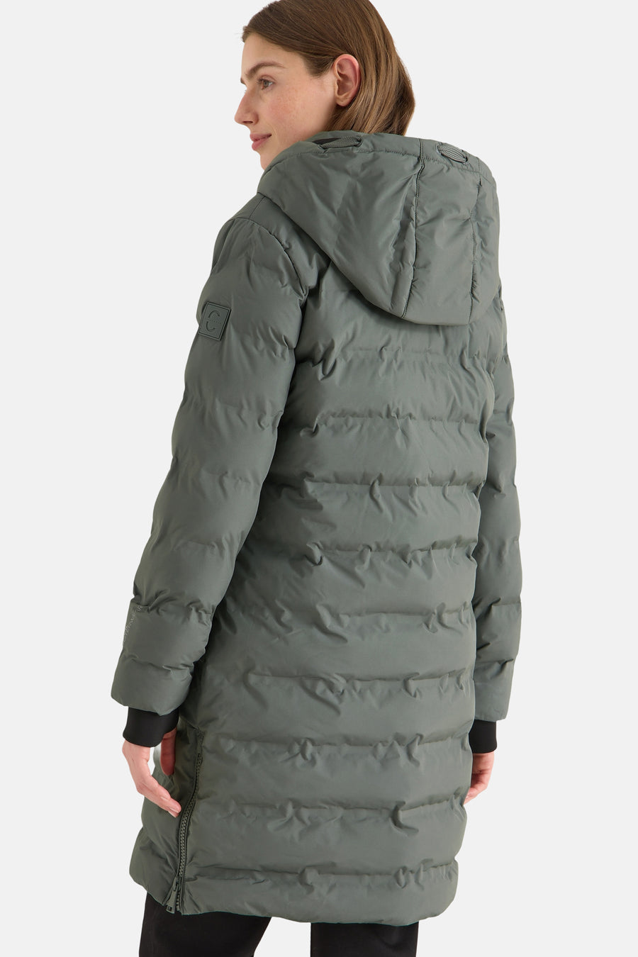 Veste longue verte par CECIL avec capuche, texture matelassée et manches longues noires visibles.