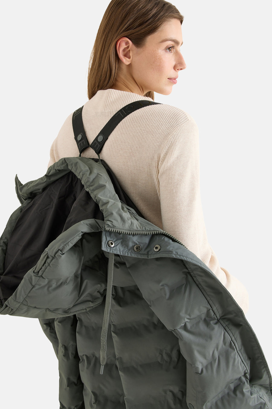 Veste longue vert de CECIL, portée avec un pull beige, bretelles noires apparentes.