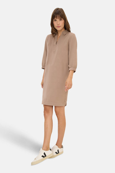 Taupe jurk met lange mouwen van CECIL, gedragen met witte sneakers met zwarte strepen.
