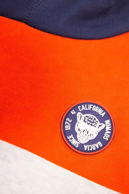Orange and navy color-block hoodie with white circular patch featuring fox design and text, close-up view