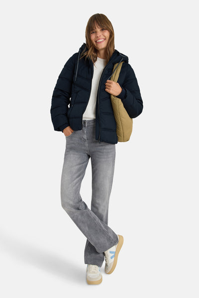 Kort blauw jasje van CECIL, gedragen met een witte trui, grijze jeans en een beige canvas tas.