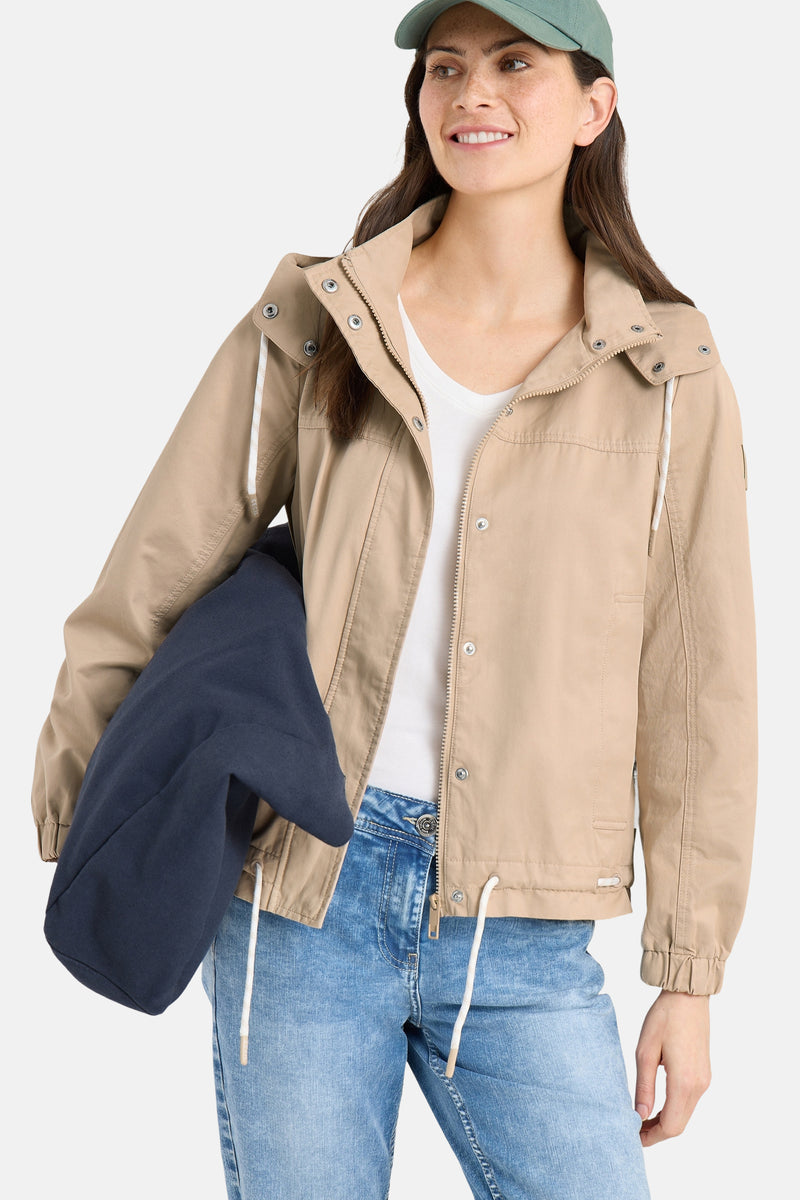 Veste courte beige de CECIL avec fermeture éclair, capuche à cordon et détails de poches.