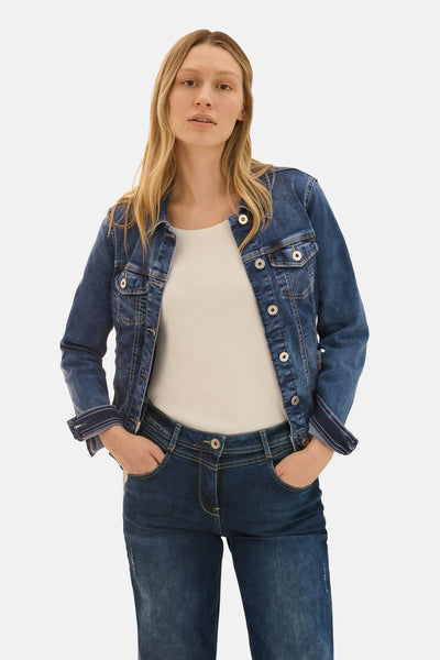Veste en jean bleu denim par CECIL, avec des boutons argentés et porté avec un t-shirt uni et un jean assorti.