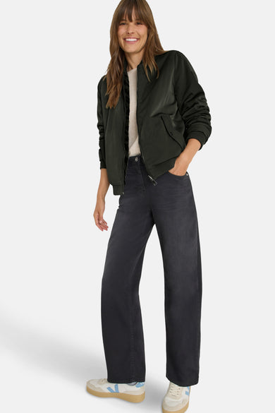 Korte groene jas van CECIL, gedragen met een zwarte jeans en beige sneakers.