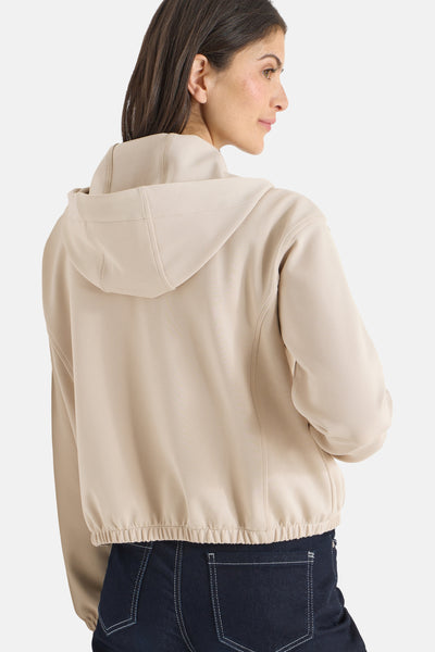 Gilet beige de CECIL, avec capuche et ourlet élastique, porté avec un jean.