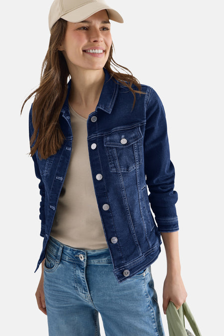 Veste en jean bleu denim par CECIL, avec boutons argentés, portée sur un t-shirt beige et un jean délavé.
