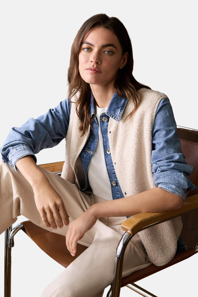 Beige gilet van CECIL, casual stijl gedragen over een wit T-shirt en een spijkerblouse, zittend op een stoel.