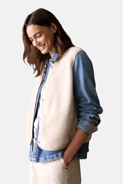 Beige mouwloos vest van imitatie schapenvacht van CECIL, gedragen met een spijkerblouse.