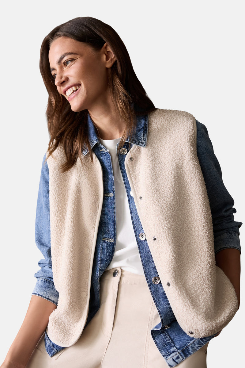 Beige teddyfleece gilet van CECIL met drukknoopsluiting, gedragen over een spijkerjasje en een beige broek.