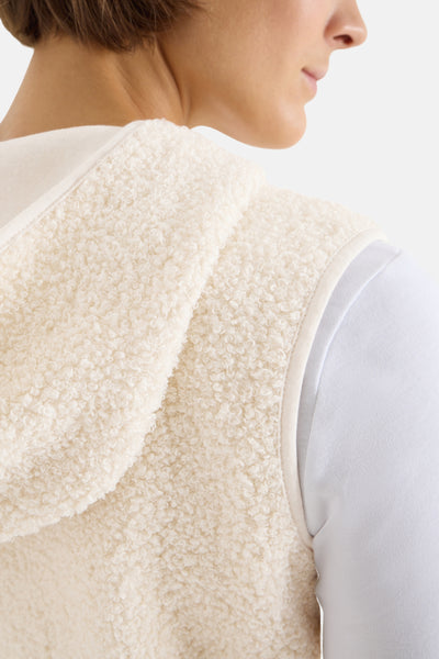 Veste courte beige de CECIL, texture bouclée et détails de finition ton sur ton, portée avec un t-shirt blanc.
