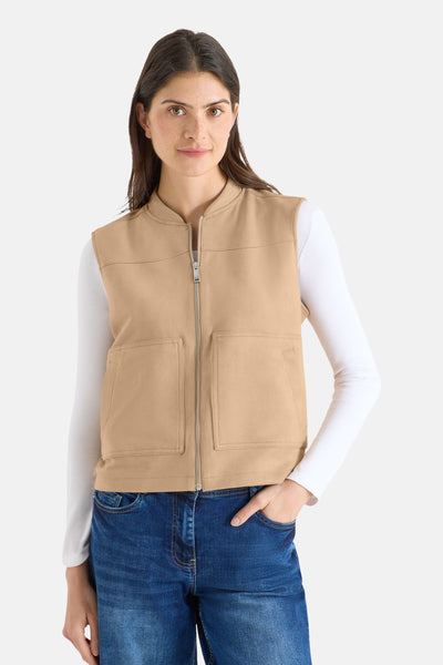 Bruin mouwloos vest van CECIL, met ritssluiting en opgestikte zakken, gedragen over een witte top en een blauwe jeans.