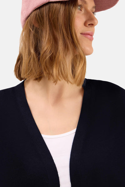 Gilet bleu marine de CECIL, porté sur un débardeur blanc, avec un chapeau rose.
