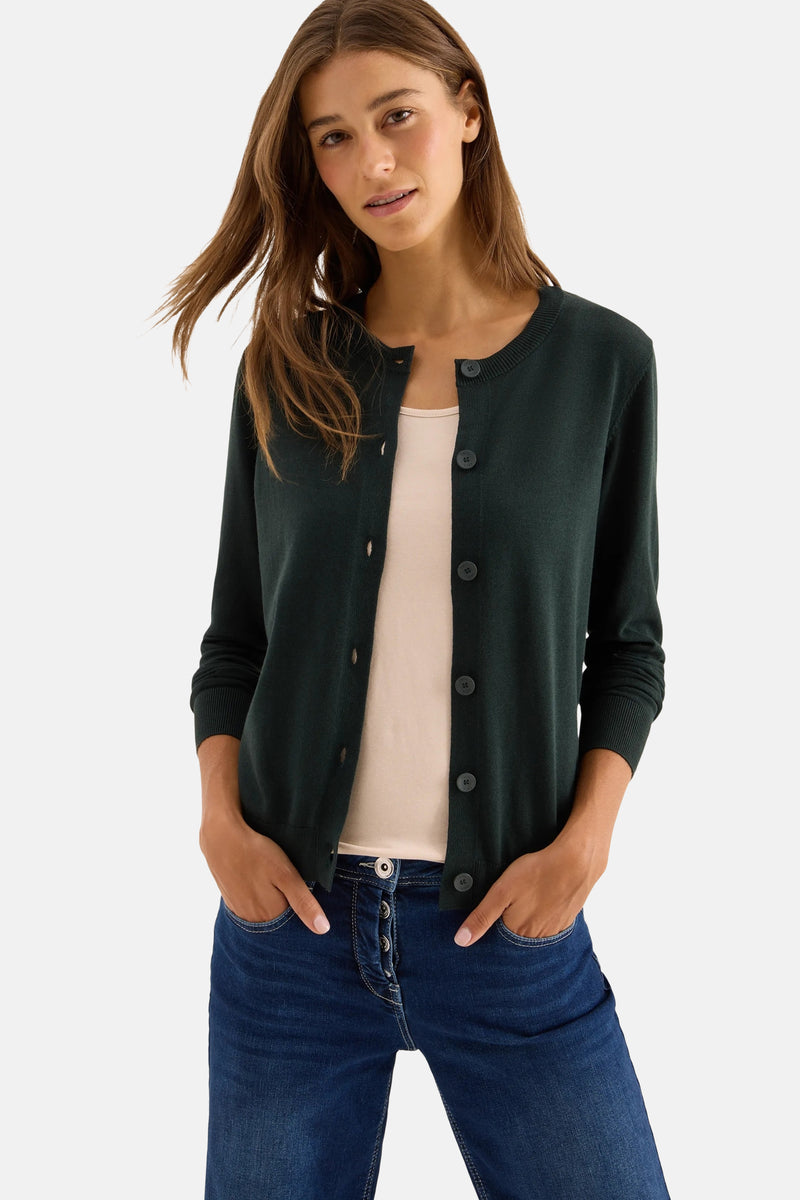 Groene gebreide cardigan van CECIL, gedragen over een hemdje, met een high-waisted jeans.