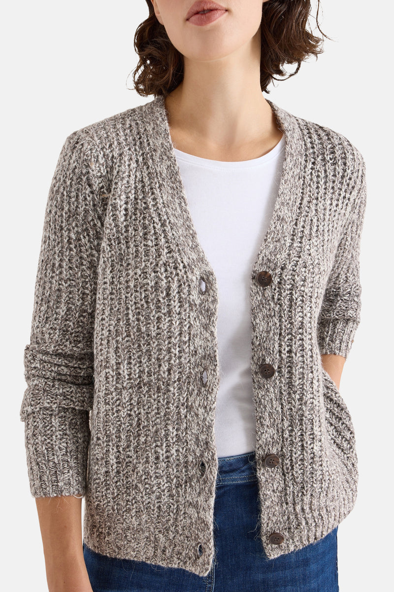 Taupe kabelgebreid vest van CECIL, gedragen over een wit T-shirt en een spijkerbroek.
