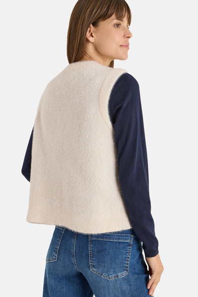 Gilet ecru CECIL, gedragen over een donkergroene trui en een jeans, rugweergave.