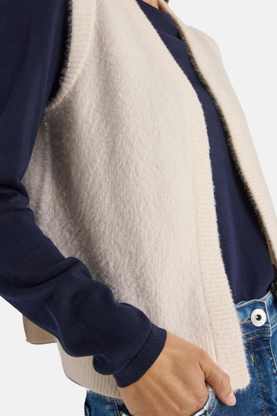 Ecru gilet van CECIL, gedragen over een marineblauw T-shirt en een spijkerbroek, textuurdetail van de stof.