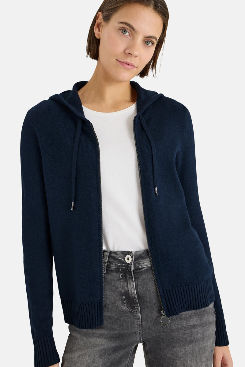 Blauwe cardigan van CECIL, gedragen over een wit T-shirt, met een grijze jeans en zilveren sneakers.