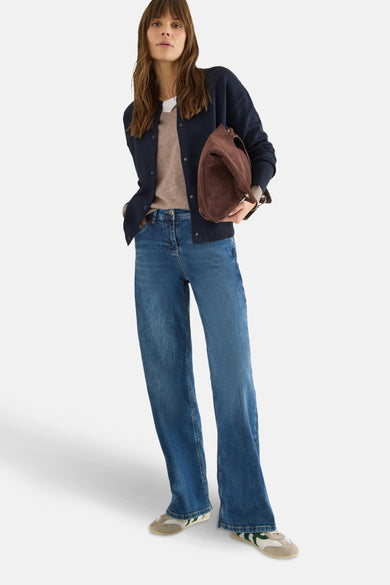 Blauwe CECIL-cardigan gedragen met een beige trui, wijde jeans en een suède handtas.