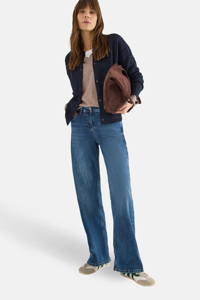 Blauwe CECIL-cardigan, gedragen met een beige T-shirt, een blauwe jeans en een bruine suède tas.