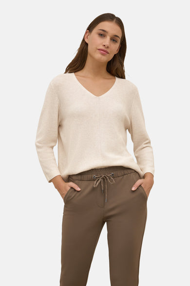 Beige V-hals trui van CECIL, gedragen met een bruine broek met trekkoord.