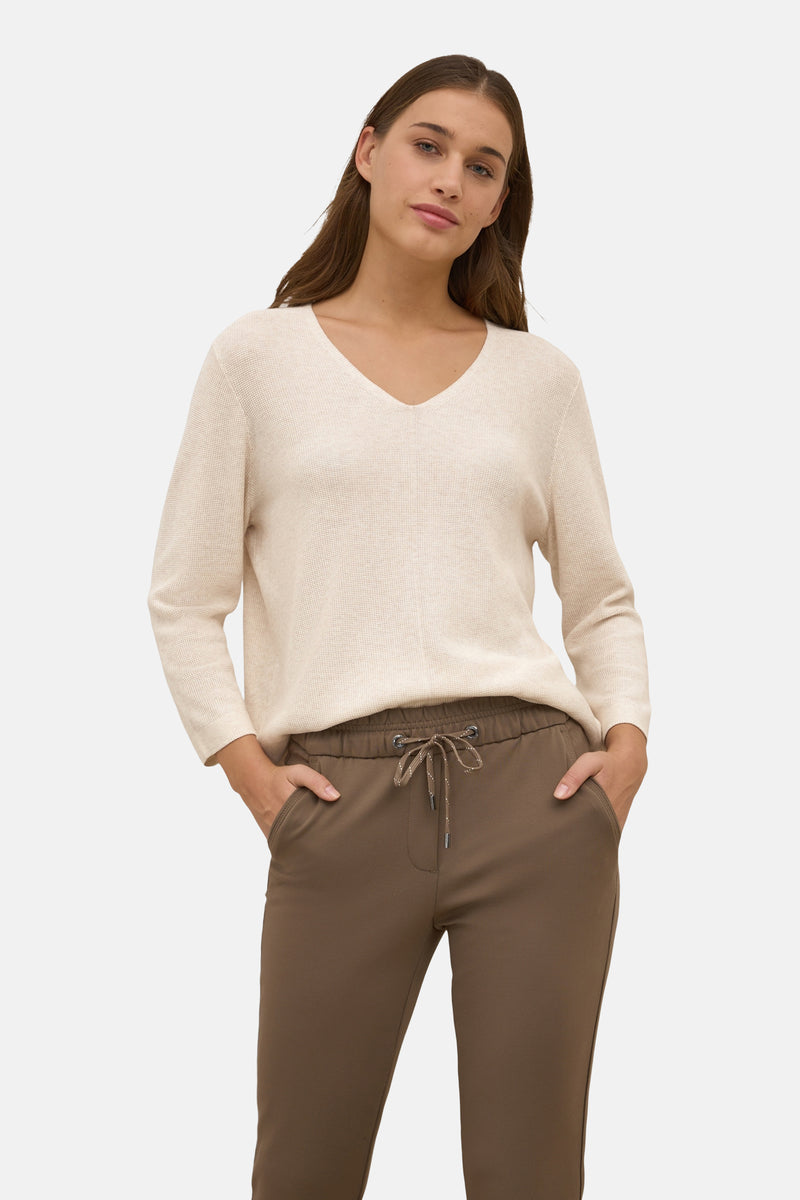 Beige V-hals trui van CECIL, gedragen met een bruine broek met trekkoord.