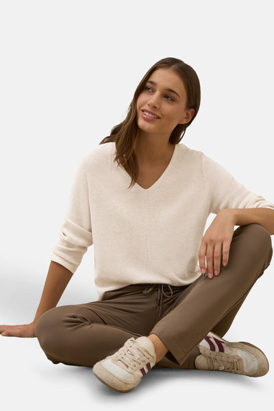 Beige V-hals trui van CECIL, gedragen met een bruine broek en vintage sneakers.