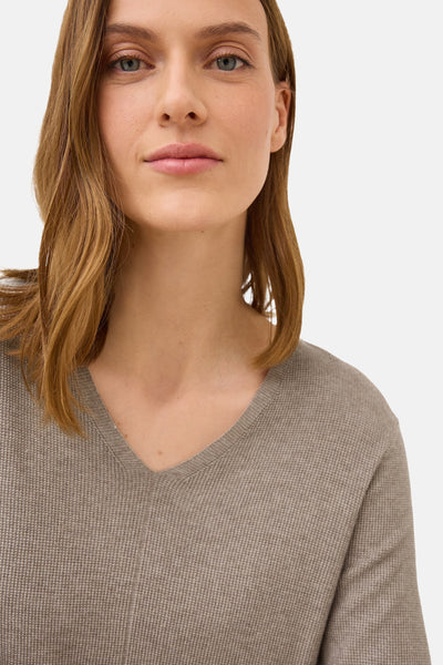 Pull col en V brun de CECIL en maille gaufrée texturée, porté par une femme.
