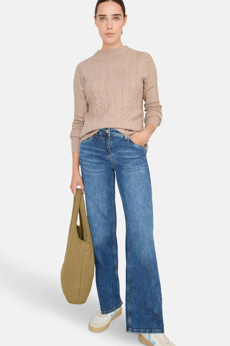 Beige kabeltrui van CECIL, gedragen met een blauwe jeans en een kaki stoffen tas.