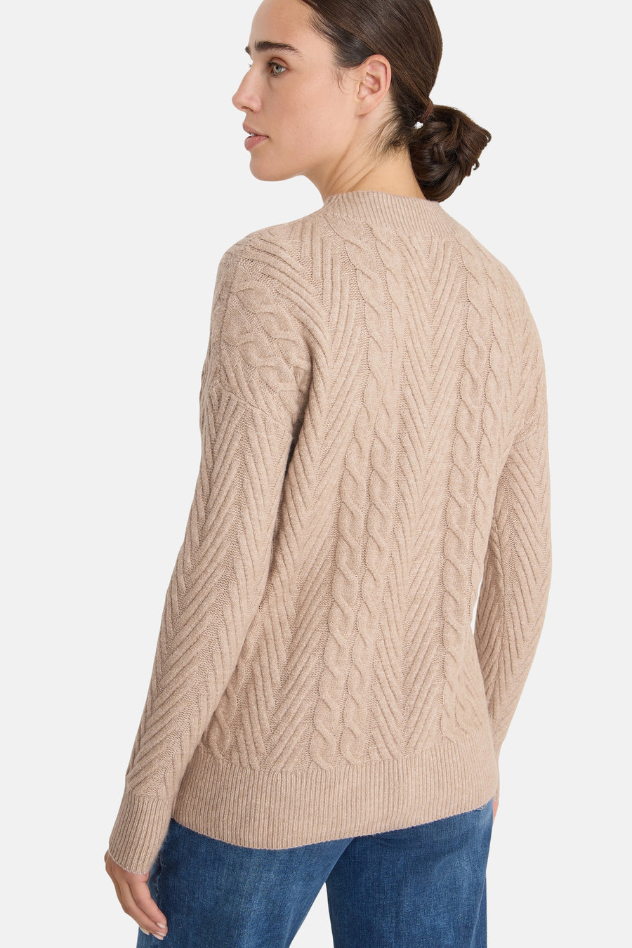 Beige kabeltrui van CECIL, met een visgraatpatroon en gedragen met een spijkerbroek.