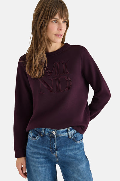 Mauve sweatshirt met ronde hals van CECIL, met decoratieve toon-op-toon opschrift, gedragen met een blauwe jeans.