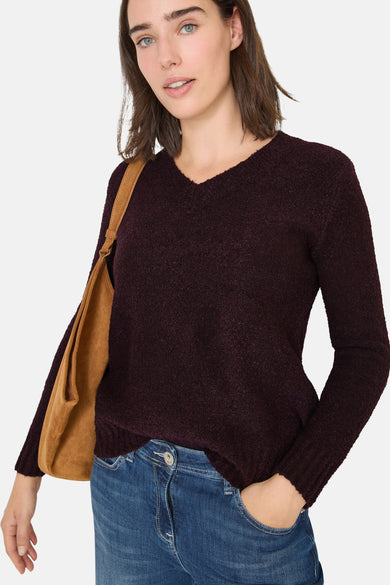 V-hals trui rood van CECIL, gedragen met een wijde blauwe jeans en een bruine suède tas.