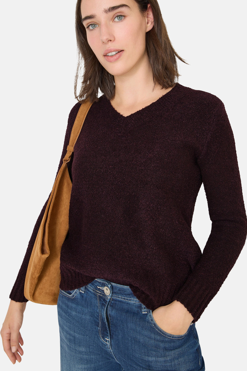 V-hals trui rood van CECIL, gedragen met een wijde blauwe jeans en een bruine suède tas.