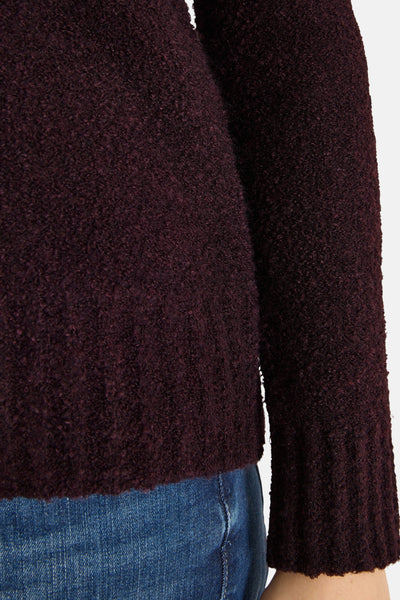 Cecil rode V-hals trui in getextureerd lusbreiwerk gedragen met een blauwe jeans.