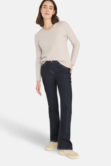 Pull col V beige de CECIL, porté avec un jean brut et des baskets couleur crème.
