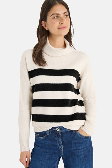 Pull rayé en maille multicolore de CECIL, porté avec un jean bleu.
