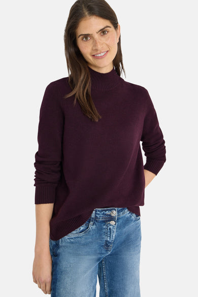 Bordeaux coltrui van CECIL, gedragen met een spijkerbroek en beige en witte sneakers.