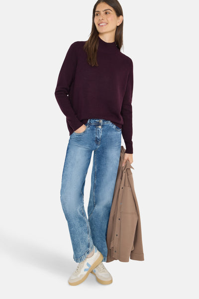 Pull à col roulé bordeaux de CECIL, porté avec un jean et des baskets beiges et blanches.