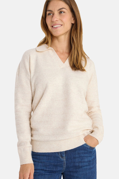 Beige trui van CECIL, met reverskraag en fijne breinaald, gedragen met een blauwe jeans.