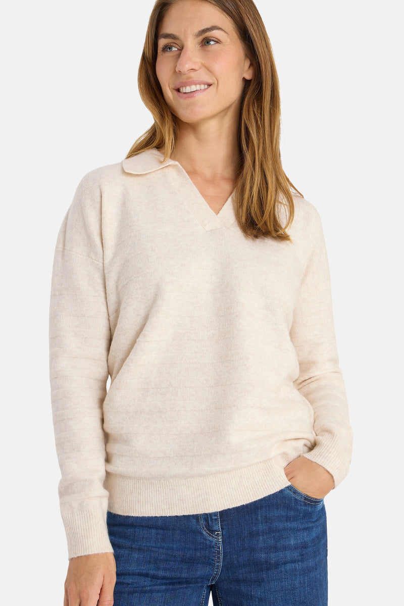 Beige trui van CECIL, met reverskraag en fijne breinaald, gedragen met een blauwe jeans.