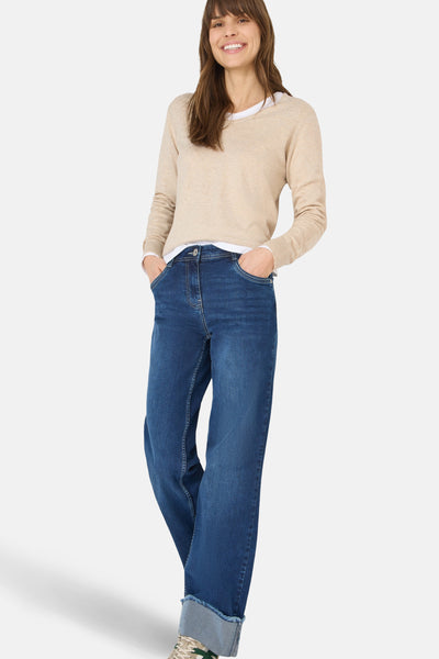 Pull à col en V beige de CECIL, porté sur un t-shirt blanc, avec un jean bleu.
