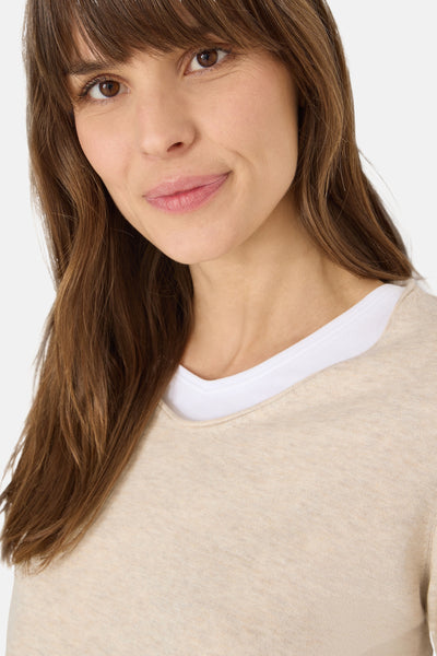 Pull à col en V beige de CECIL, porté sur un t-shirt blanc à col en V, en gros plan.